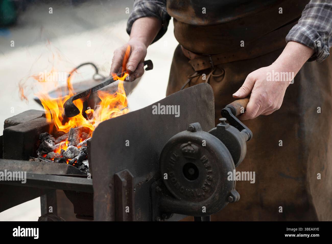 Metallo riscaldante del fabbro in un forno aperto Foto Stock