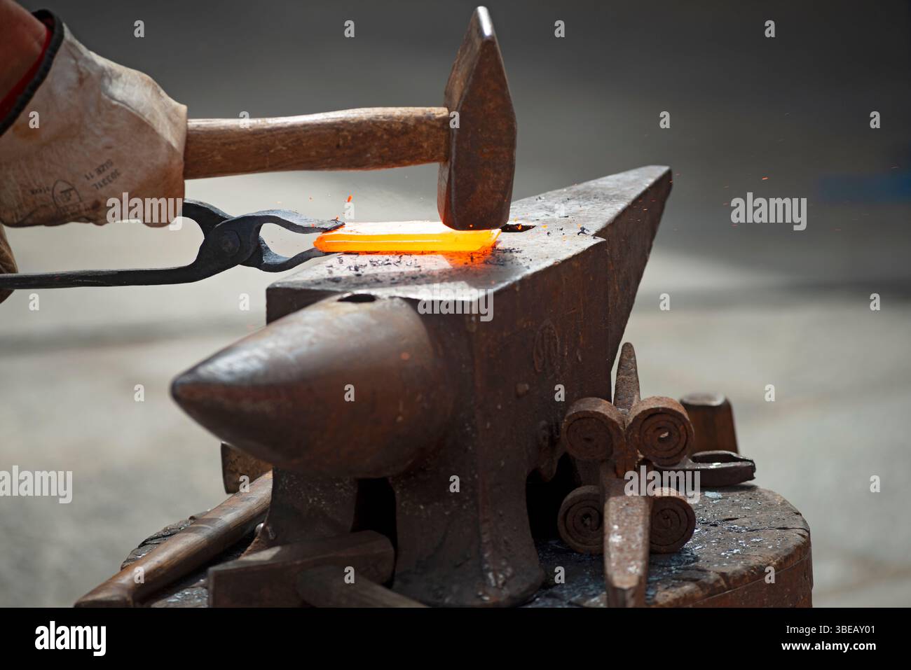 Fabbro di forgiare un Red Hot pezzo di ferro Foto Stock