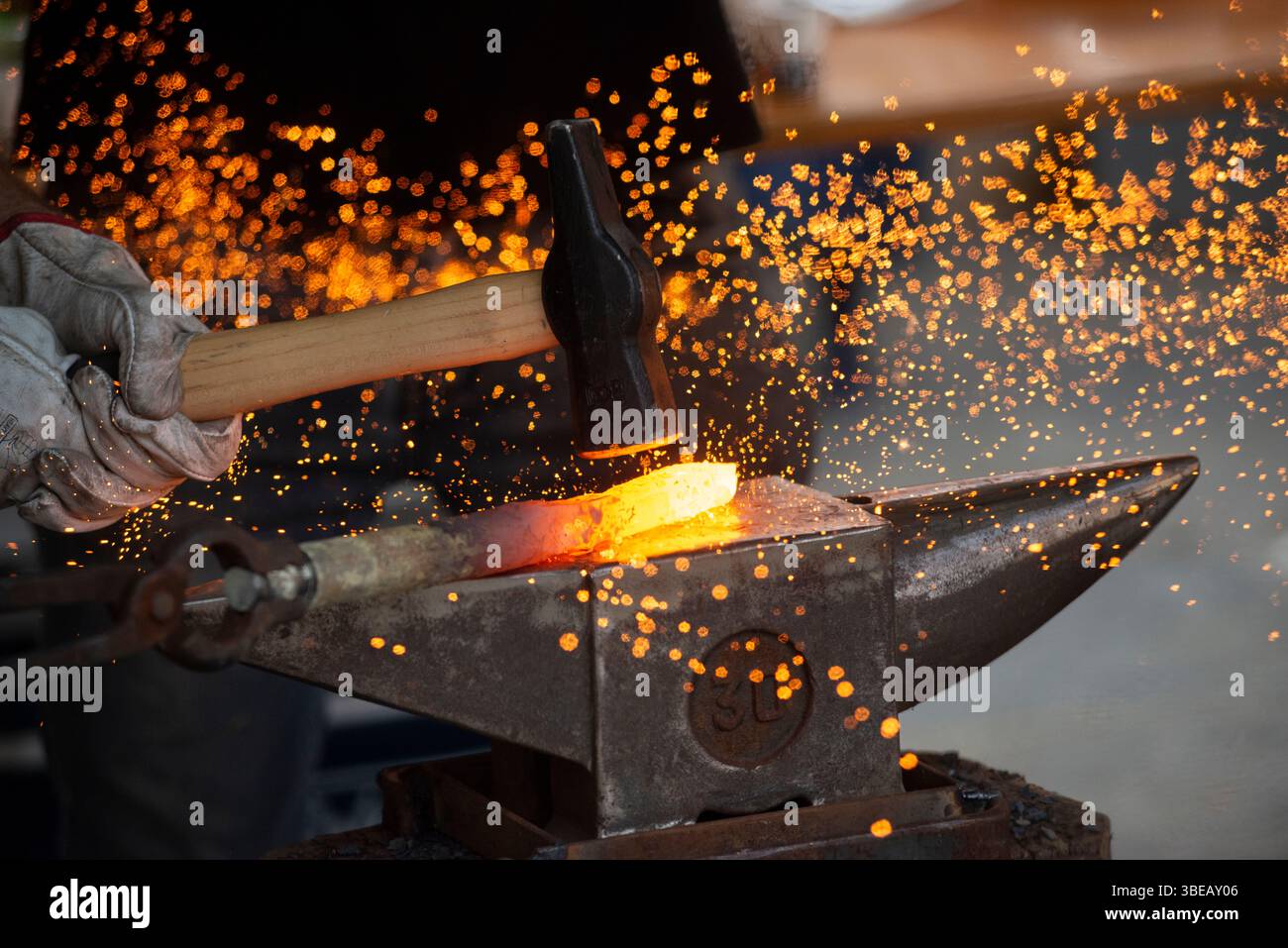 Fabbro di forgiare un Red Hot pezzo di ferro Foto Stock