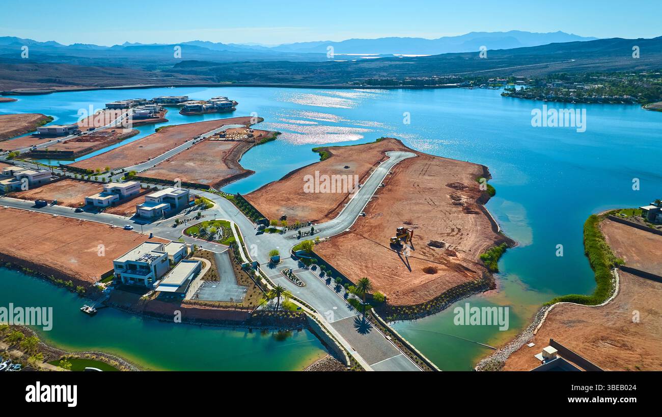 Volo aereo sopra le moderne case sul lago e lo sviluppo del deserto con acqua frizzante Foto Stock