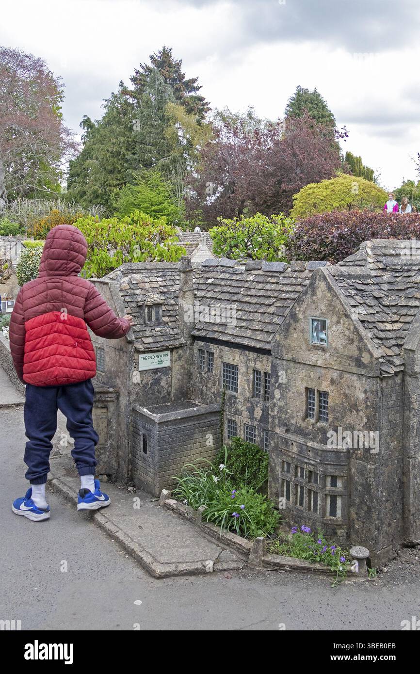 Piccolo bambino che guarda a edifici, villaggi in miniatura, Bourton-on-the-Water, Cotswolds, Gloucestershire, Inghilterra, Regno Unito, Europa Foto Stock