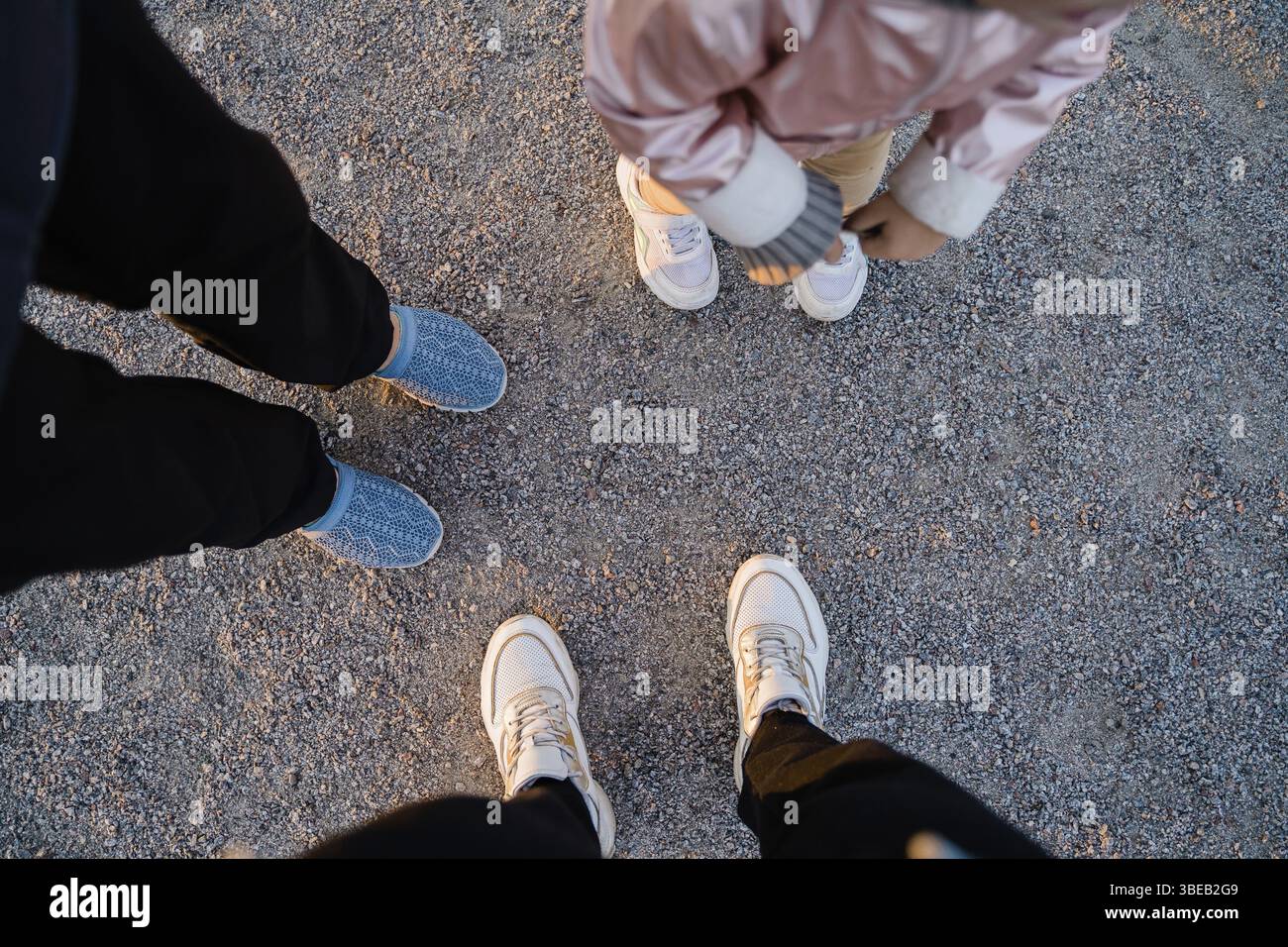 Vista dall'alto delle gambe della famiglia a terra all'aperto. Tempo di Unione insieme. Cose semplici. Foto Stock