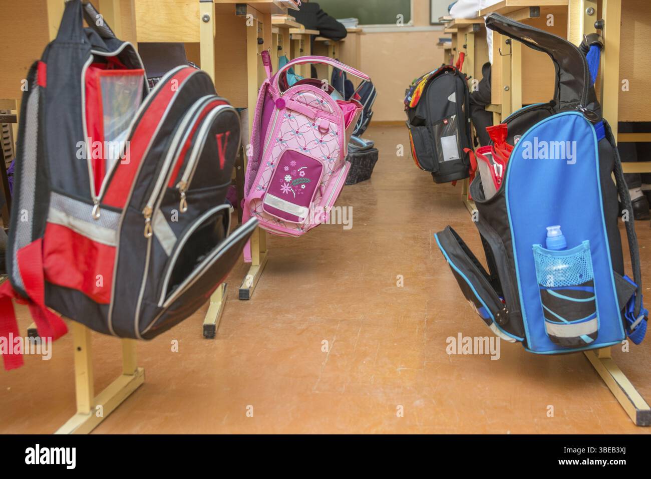 Anapa, Russia - 28 Febbraio 2017: scuola di sacchi appesi su appendiabiti su entrambi i lati del corridoio tra le scrivanie in aula Foto Stock