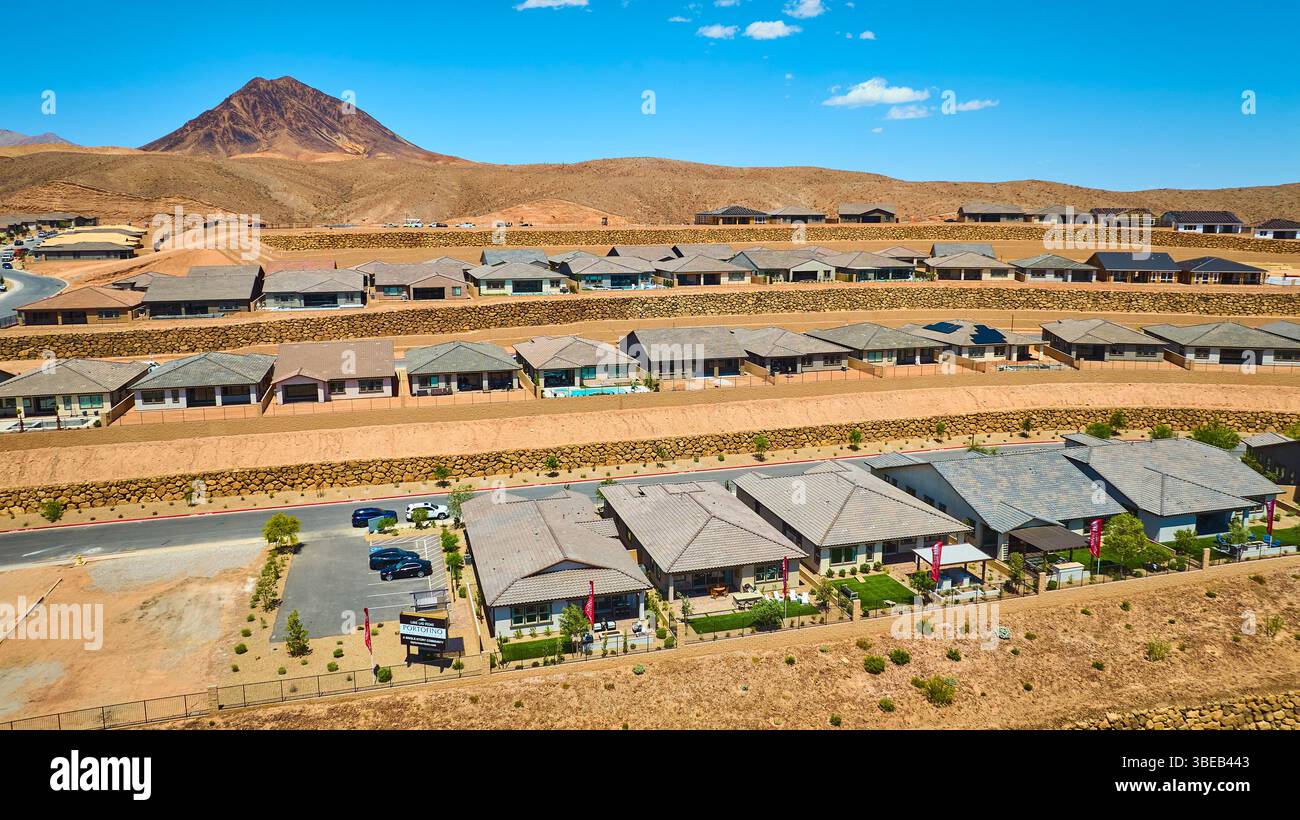 Sviluppo aereo delle abitazioni suburbane del deserto con sfondo di montagna Fly Over Foto Stock