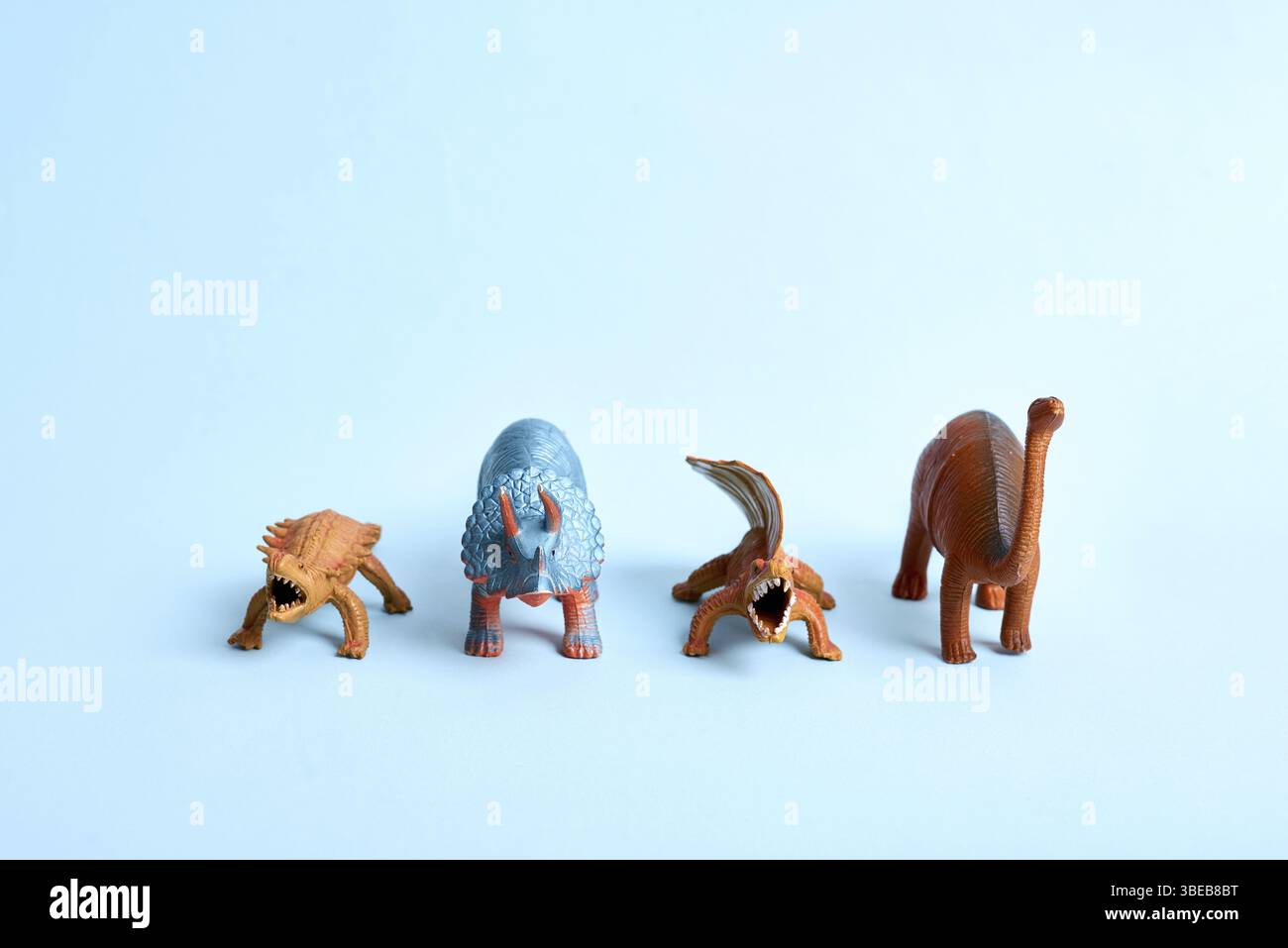 Torre di dinosauro giocattolo su sfondo blu. Simpatico poster preistorico. Copia spazio Foto Stock