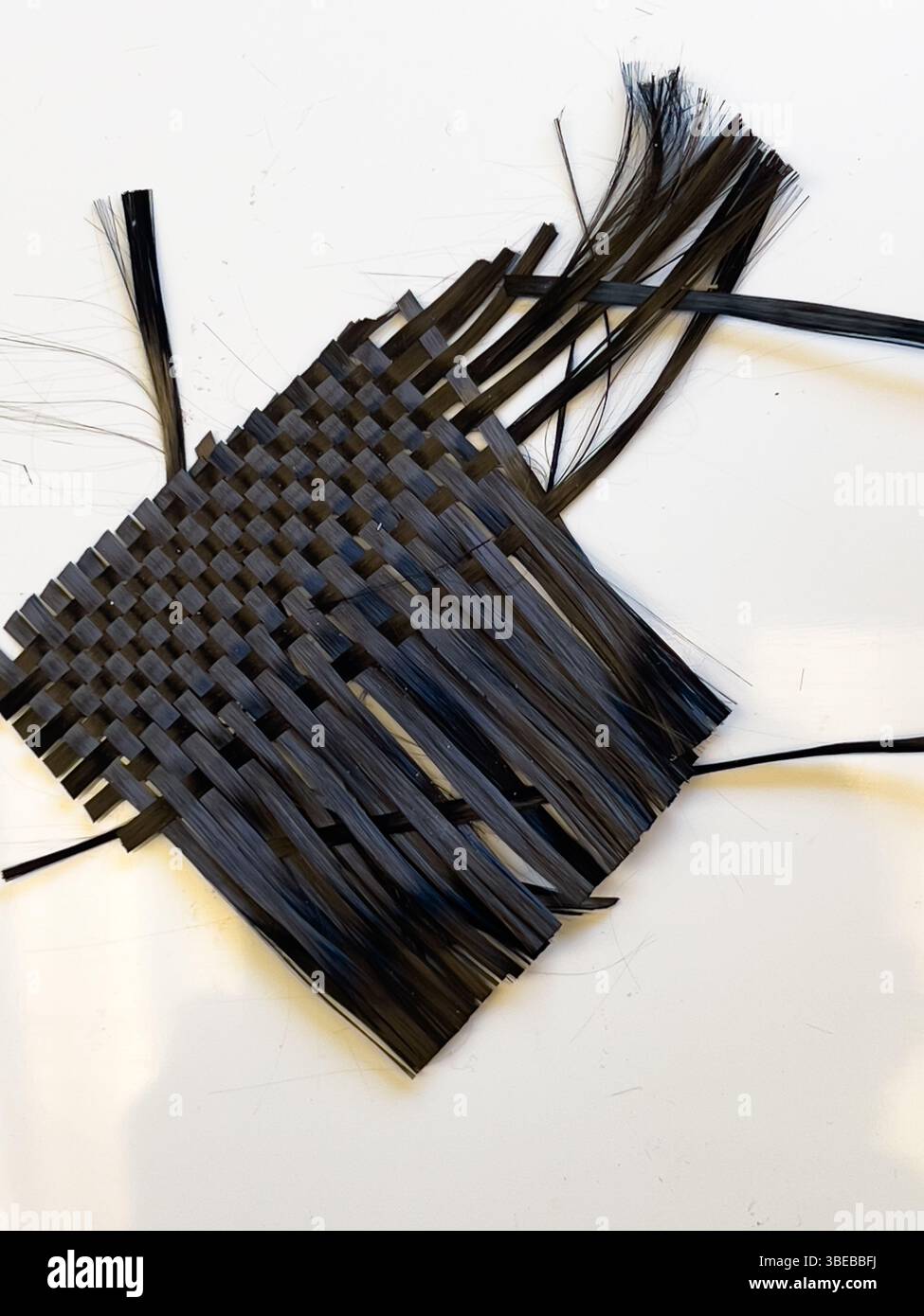 Materiale opaco in fibra di carbonio intrecciato che mostra i trefoli prima dell'applicazione della resina plastica Foto Stock