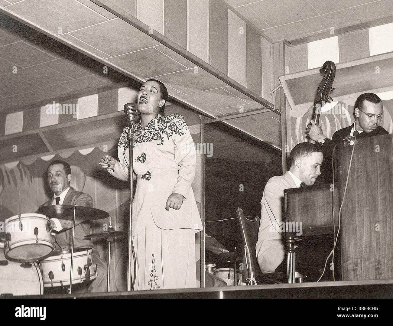Billie Holiday si esibisce al Club Bali, Washington, con al Dunn (batteria) e Bobby Tucker (pianoforte) nel 1948. BBillie Holiday, nata Eleanora Fagan (New York, 7 aprile 1915 – New York, 17 luglio 1959), è stata una cantante statunitense di musica jazz e swing. Soprannominata "Lady Day" dalla sua amica e partner musicale, Lester Young, Holiday ha dato un contributo significativo alla musica jazz e al canto pop. Il suo stile vocale, fortemente influenzato dagli strumentisti jazz, ha ispirato un nuovo modo di manipolare il fraseggio e il tempo. Holiday era nota per le sue doti vocali e improvvisative. Immagine di Ralph F. Seghers c/o Ken Seghers - Scan Foto Stock