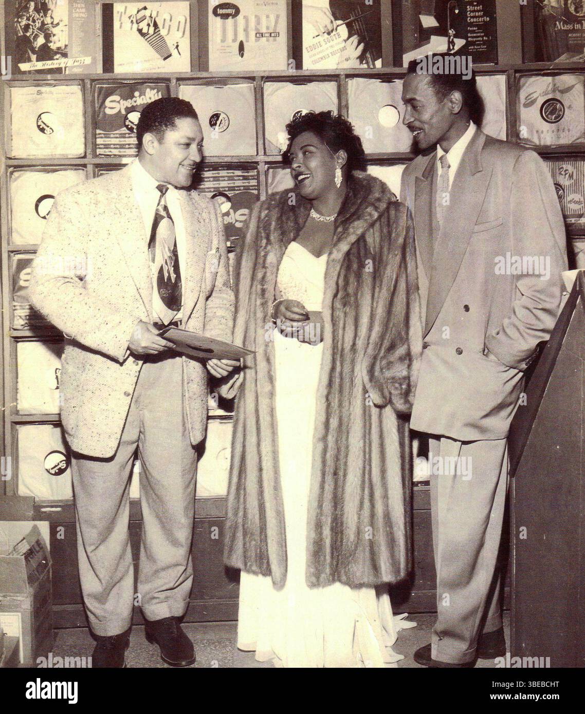 John Dolphin e Billie Holiday al Dolphin's of Hollywood record Shop a Los Angeles, California. Billie Holiday, nata Eleanora Fagan (New York, 7 aprile 1915 – New York, 17 luglio 1959), è stata una cantante statunitense di musica jazz e swing. Soprannominata "Lady Day" dalla sua amica e partner musicale, Lester Young, Holiday ha dato un contributo significativo alla musica jazz e al canto pop. Il suo stile vocale, fortemente influenzato dagli strumentisti jazz, ha ispirato un nuovo modo di manipolare il fraseggio e il tempo. Holiday era nota per le sue doti vocali e improvvisative Foto Stock