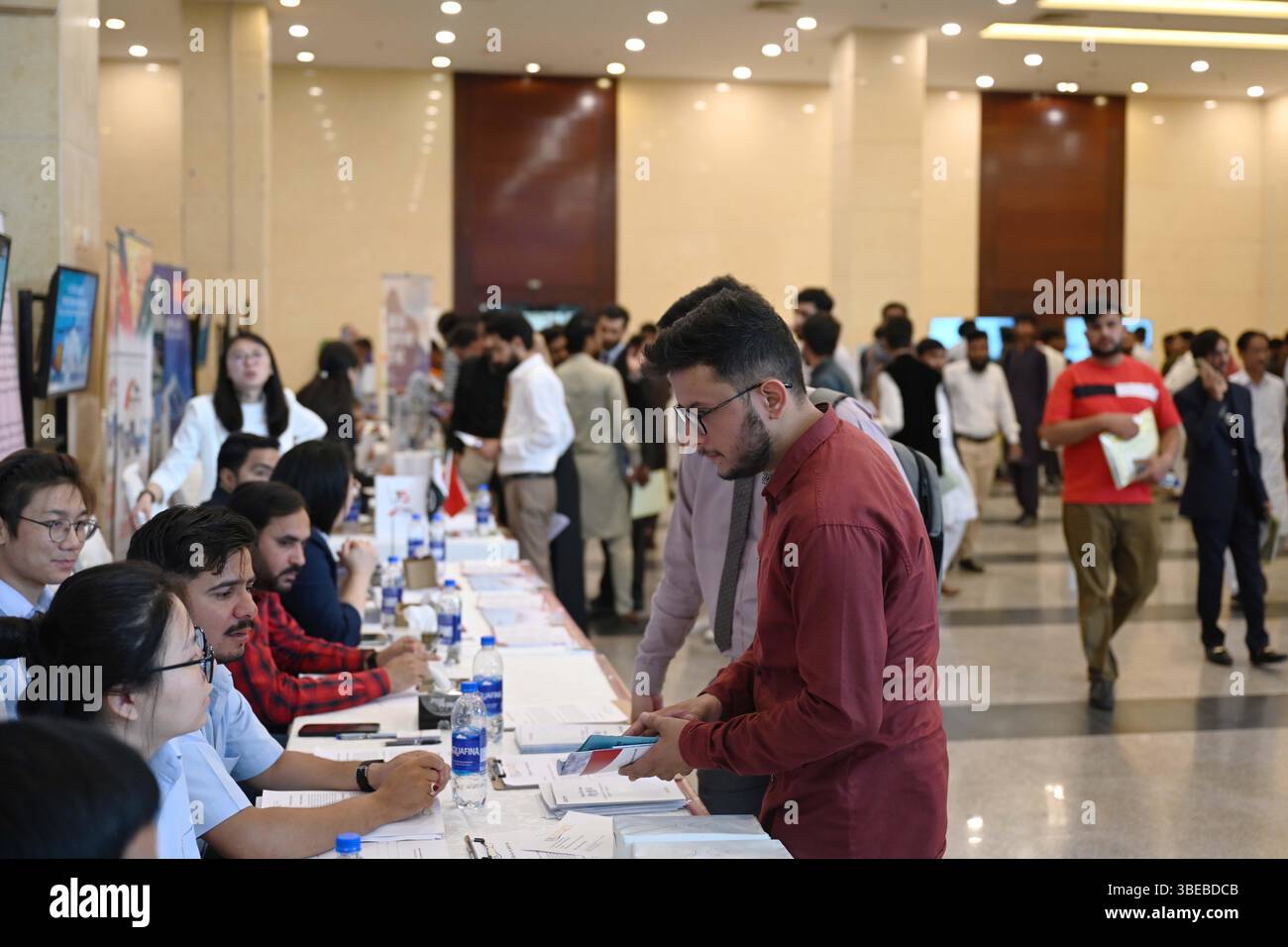 Islamabad, Pakistan. 27 maggio 2025. La gente partecipa a una fiera del lavoro a Islamabad, Pakistan, il 27 maggio 2025. Organizzato congiuntamente dalla camera di commercio cinese in Pakistan (CCCP) e dalla Commissione nazionale per la formazione professionale e tecnica (NAVTTC) pakistana, l'evento ha riunito 20 importanti società cinesi che offrono posizioni in vari settori, tra cui ingegneria, gestione di progetti, finanza, mestieri specializzati, e ruoli amministrativi. Crediti: Ahmad Kamal/Xinhua/Alamy Live News Foto Stock
