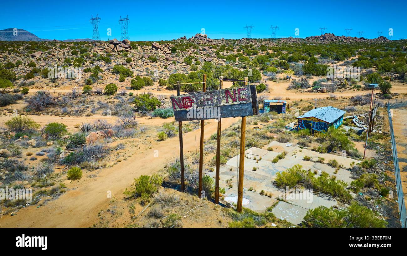 Aerial ha abbandonato Desert NOTHING Billboard e Graffiti Ruins with Power Lines Foto Stock