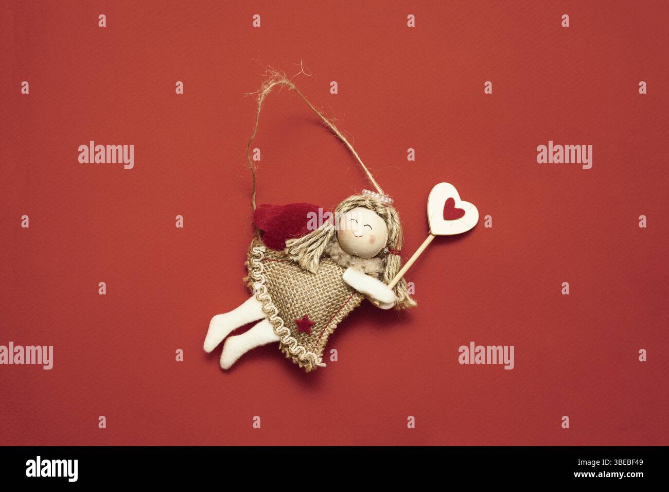Vista dall'alto della decorazione di angeli volanti su sfondo rosso. Copia spazio Foto Stock