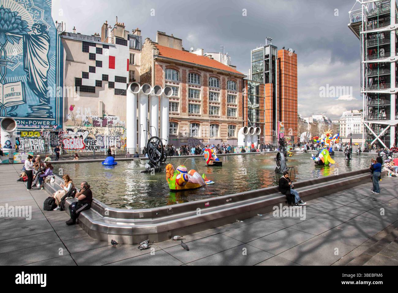 Persone che si rilassano intorno a Fontaine Stravinsky in Place Igor Stravinsky nel quartiere Marais di Parigi, Francia Foto Stock