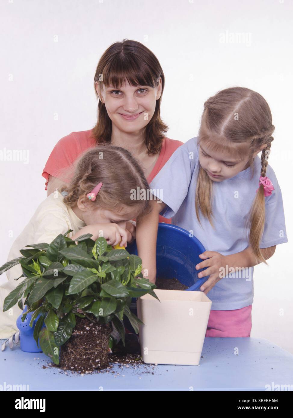Mamma e figlia di cinque anni trapiantato houseplant da un recipiente ad un altro Foto Stock