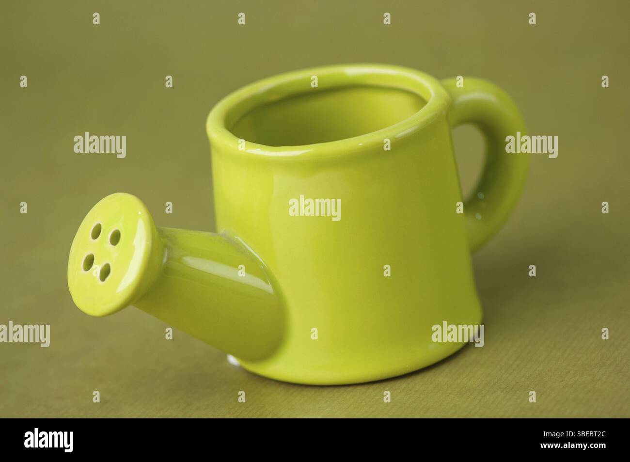 Annaffiatoio in ceramica giocattolo souvenir su uno sfondo verde da vicino Foto Stock