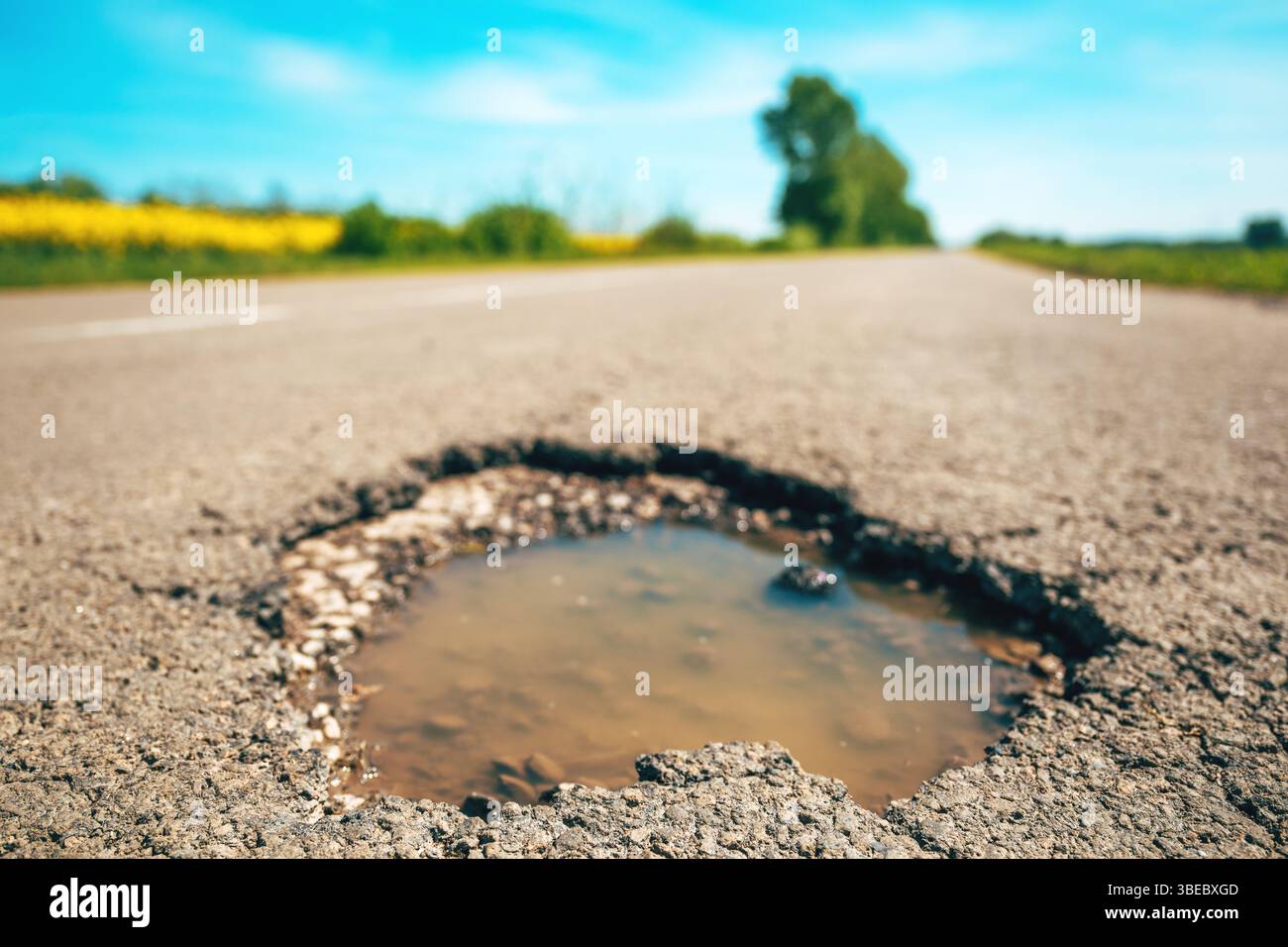 Grande foro su fondo stradale asfaltato, buco in una strada di campagna, attenzione selettiva Foto Stock