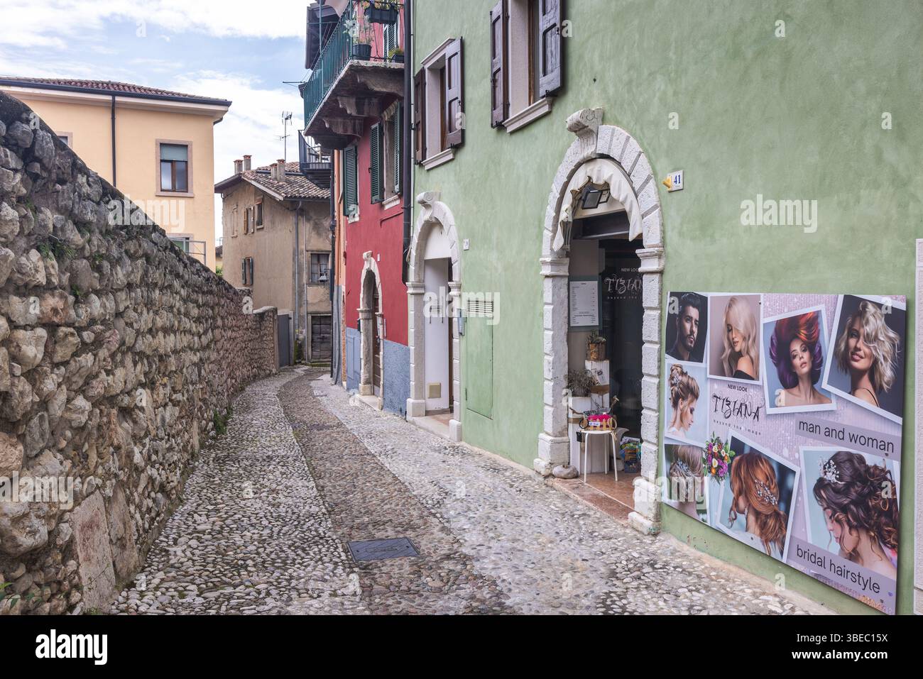MALCESINE, ITALIA - 30 MAGGIO 2024: Strada in pietra con negozi nel centro della città sulle rive del Lago di Garda. Foto Stock