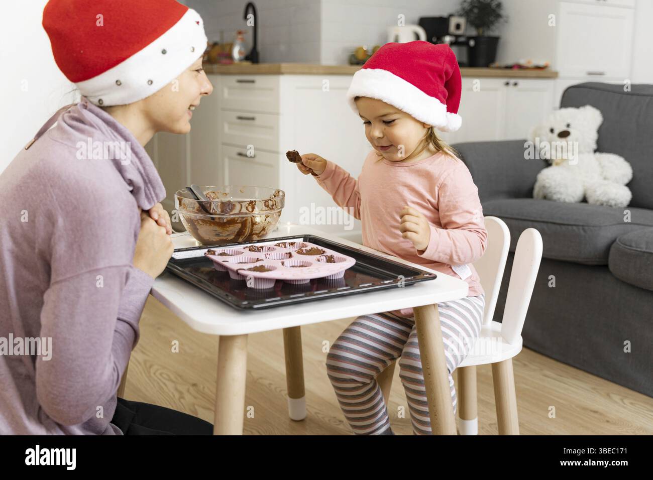 Madre con bambino che prepara biscotti per le vacanze a casa. Una famiglia felice che passa del tempo insieme. Foto Stock