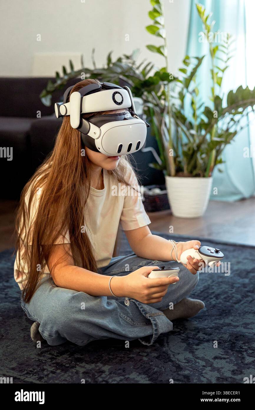 Ragazza con occhiali VR che gioca a casa. Imparare e giocare con gli occhiali per la realtà aumentata. Tecnologia e sviluppo Foto Stock