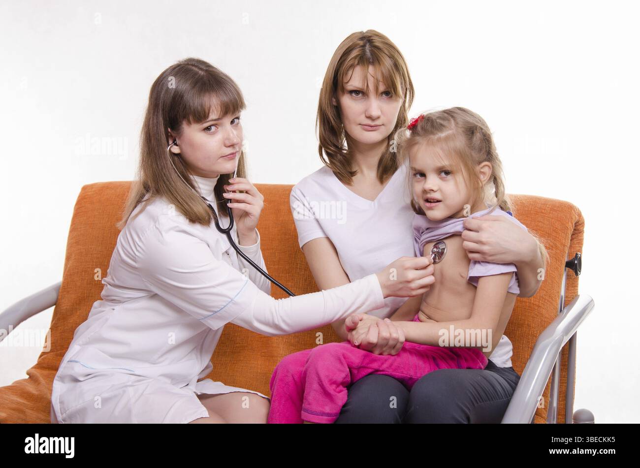 Medico pediatra esamina un bambino malato a casa in presenza di mia madre Foto Stock