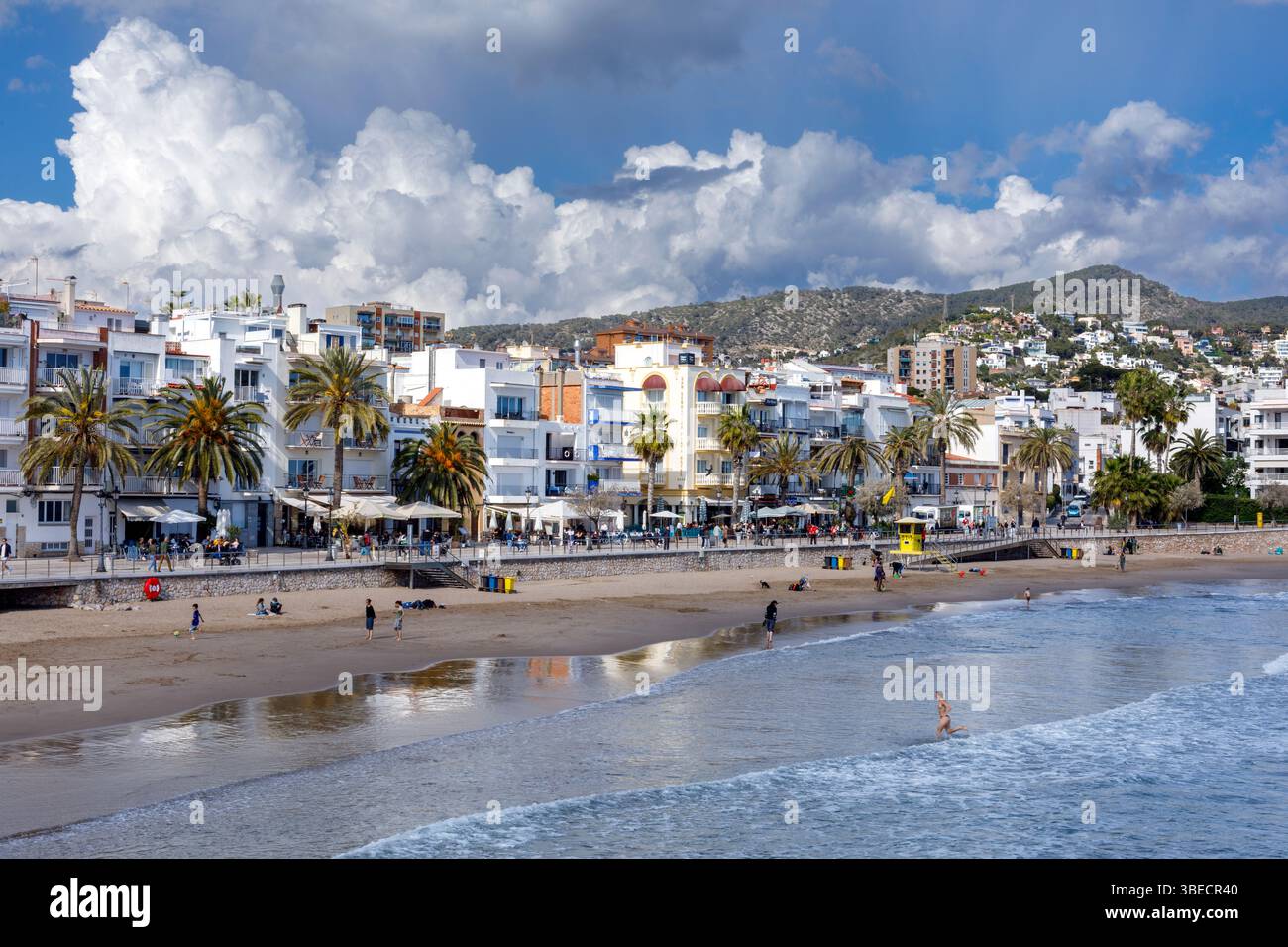 Spagna, Sitges, Spiaggia di San Sebastian, spiaggia e lungomare costeggiati da hotel e ristoranti. Foto Stock