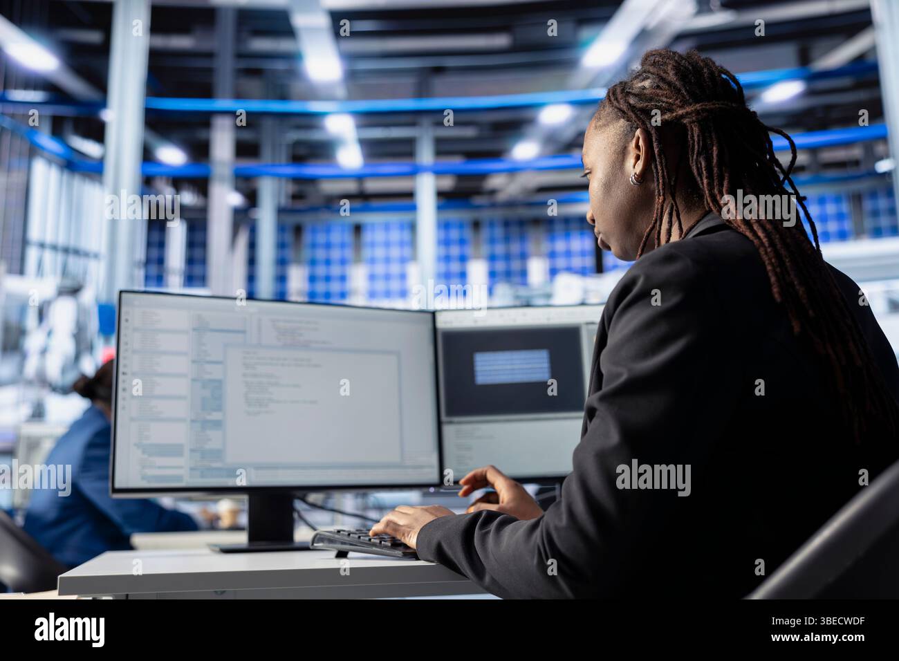 Progetta la codifica presso la workstation nell'impianto di produzione di pannelli solari, sviluppando programmi per automatizzare i processi delle apparecchiature. Esperti di impianti fotovoltaici che scrivono script per ottimizzare le operazioni robotiche Foto Stock