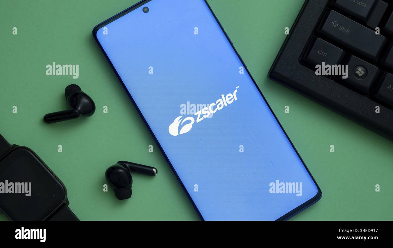 Logo Zscaler sullo schermo di uno smartphone abbinato ad accessori tecnologici Foto Stock