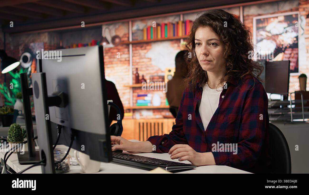 Dipendente che lavora in un ufficio startup innovativo utilizzando linguaggi di programmazione per creare applicazioni. Agenzia di sviluppo software specializzata IN IT che ottimizza il codice, digita sulla tastiera del computer, fotocamera A. Foto Stock