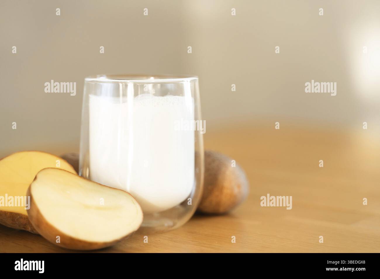 Foto del latte di patate su sfondo in legno. Bicchiere di latte alternativo. Bevanda vegetariana a base vegetale. Bevanda senza lattosio. Foto Stock