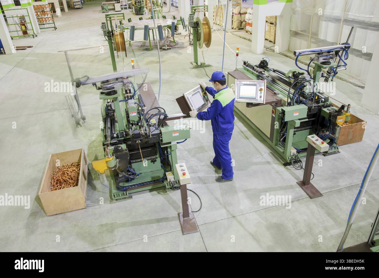 L'operaio della fabbrica da vicino taglia i tubi di rame per il radiatore dell'aria condizionata Foto Stock