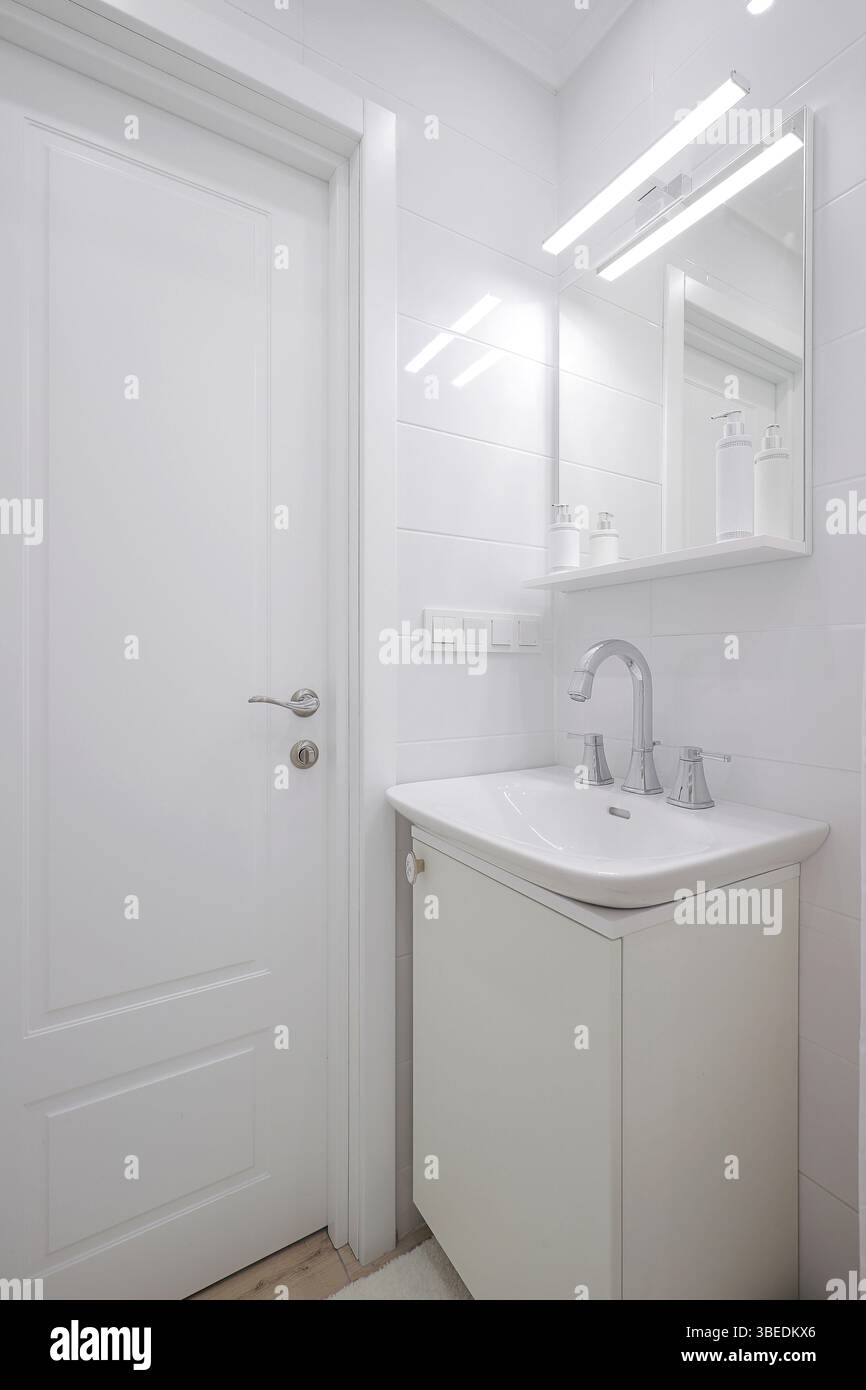 Rubinetto con lavandino in ceramica e specchio in bagno Foto Stock Rubinetto con lavandino in ceramica e specchio in bagno Foto Stock