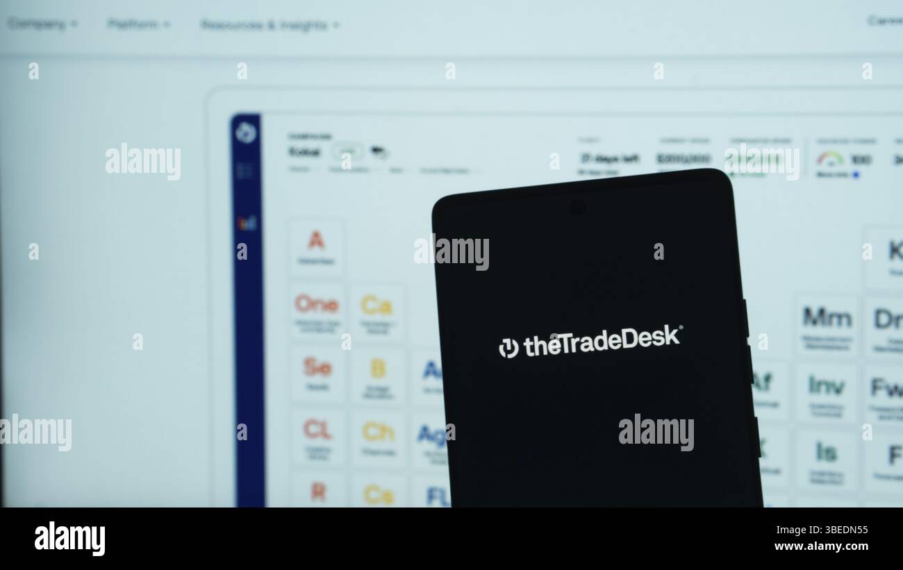 Smartphone che visualizza il logo TradeDesk su uno sfondo di logo software su uno schermo Foto Stock
