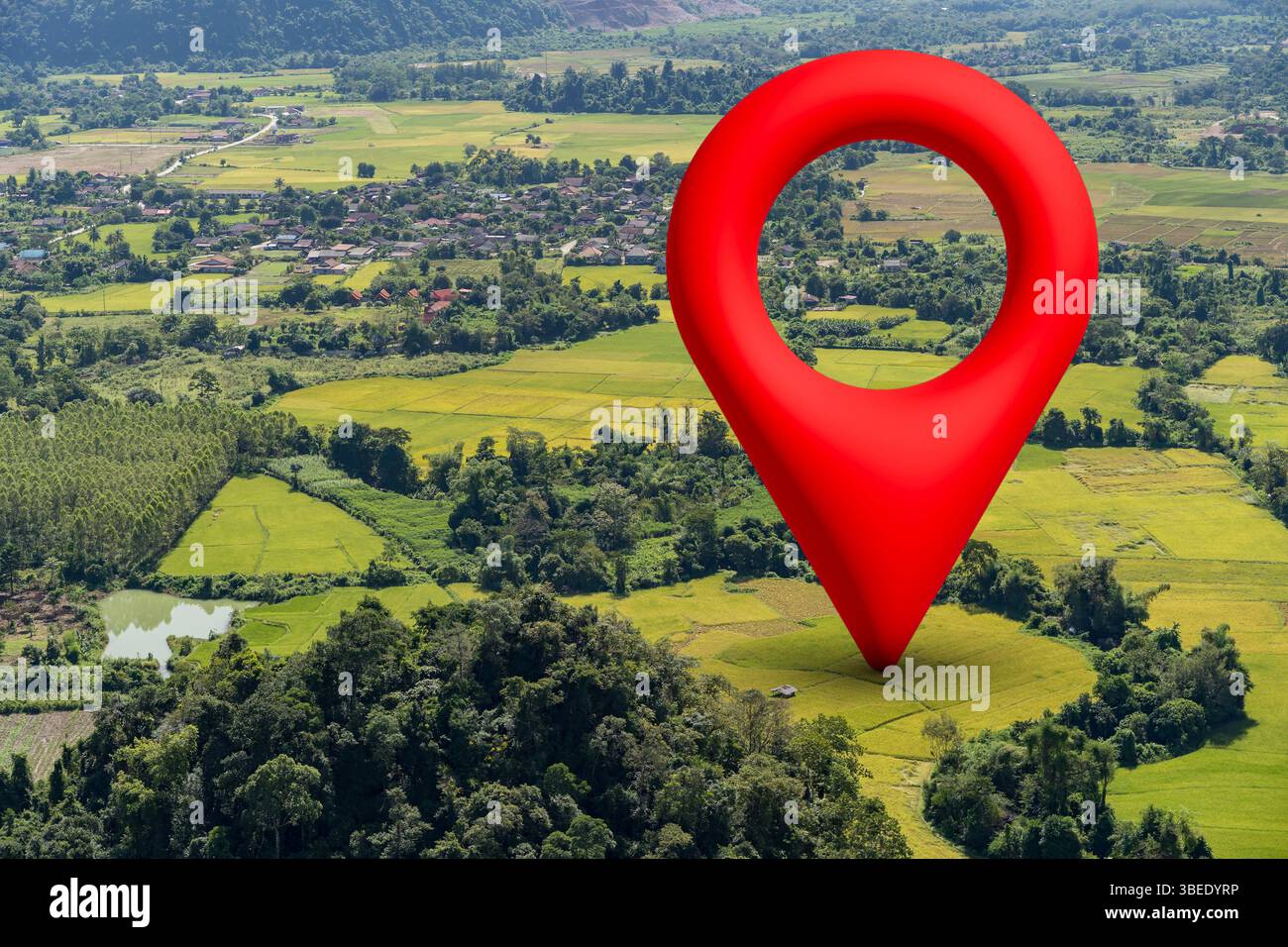 Vista aerea di una spilla rossa GPS che segna un punto su una lussureggiante campagna e villaggio, simboleggia la navigazione, il tracciamento della posizione e la mappa digitale technolo Foto Stock