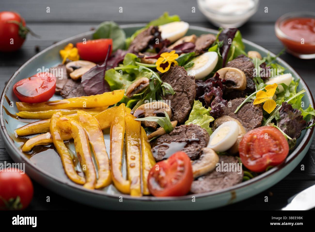 Medaglioni di manzo sfrigolanti su pepe grigliato caldo, pomodoro maturo, miscela di funghi terrosi, serviti su piatto nel ristorante per un menu audace e saporito. Foto Stock