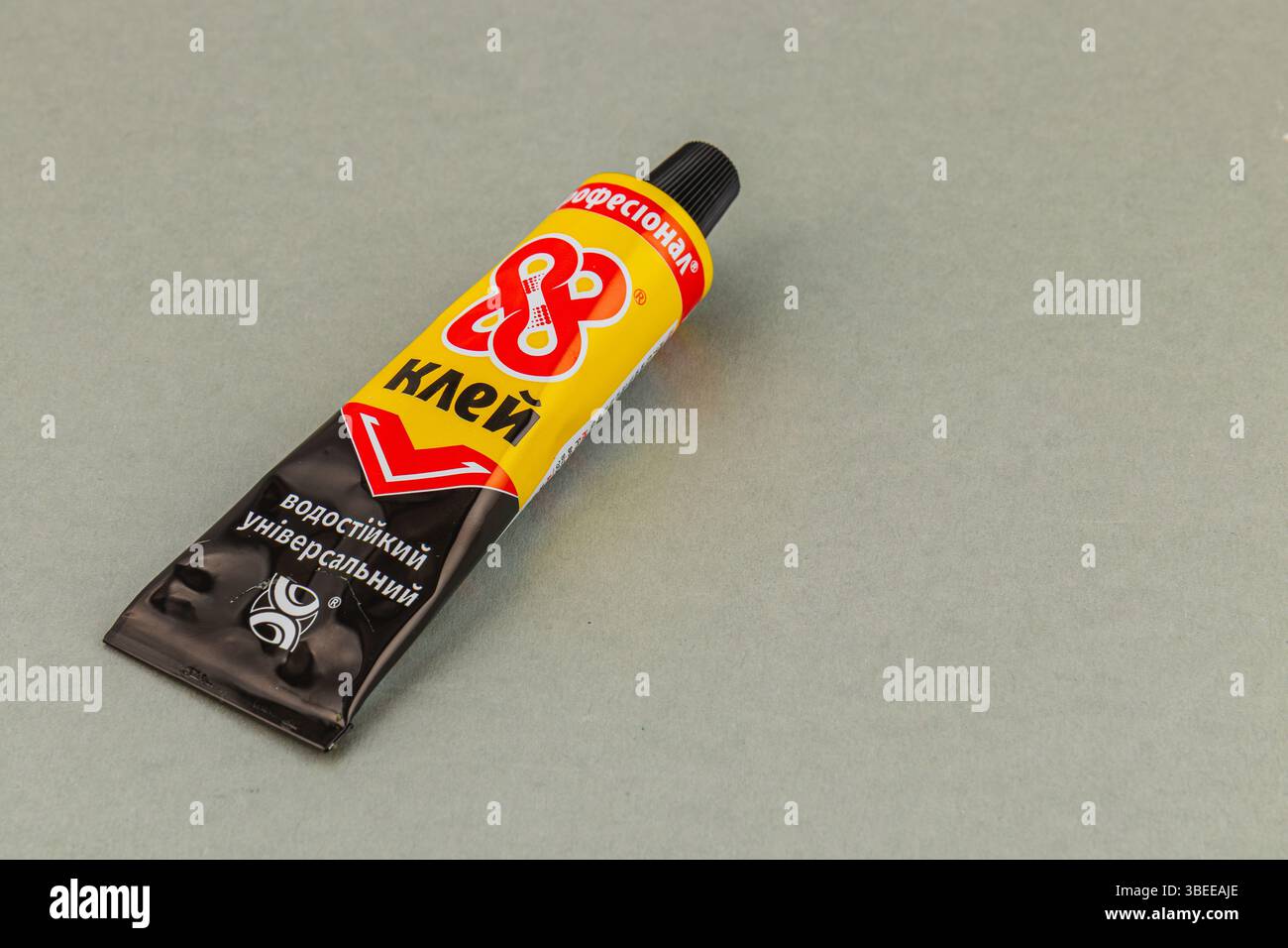 Leopoli Ucraina 05.22.25 Un tubo adesivo universale è posizionato su una superficie grigia liscia, ideale per vari progetti di artigianato, riparazioni e attività fai da te, Foto Stock