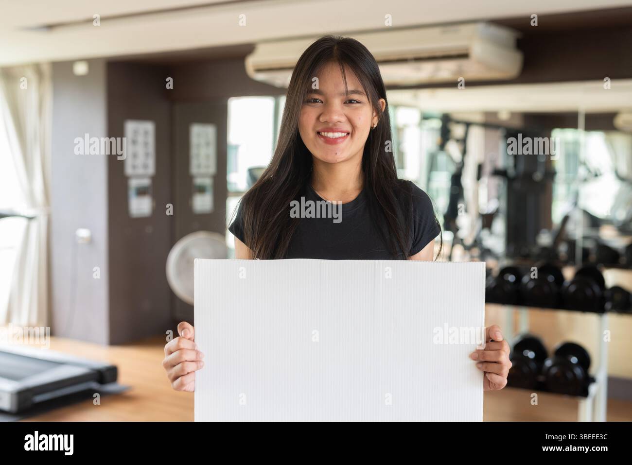 Giovane bella donna asiatica fitness che si esercita in palestra Foto Stock