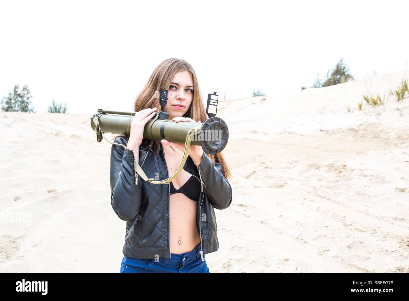 mosca, russia, 26.08.2016 Una donna tiene una pistola in un deserto. Indossa una giacca nera e un reggiseno nero Foto Stock