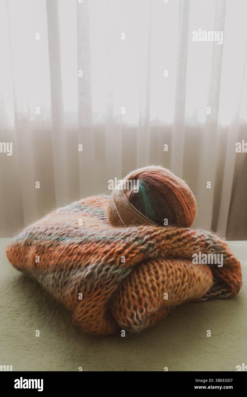 Cardigan in mohair lavorato a maglia dai colori caldi. Lavorata a maglia. Guardaroba autunno e inverno. Casa accogliente. Cose calde. Ripetizione di Unione. Maglia grossa. Foto Stock