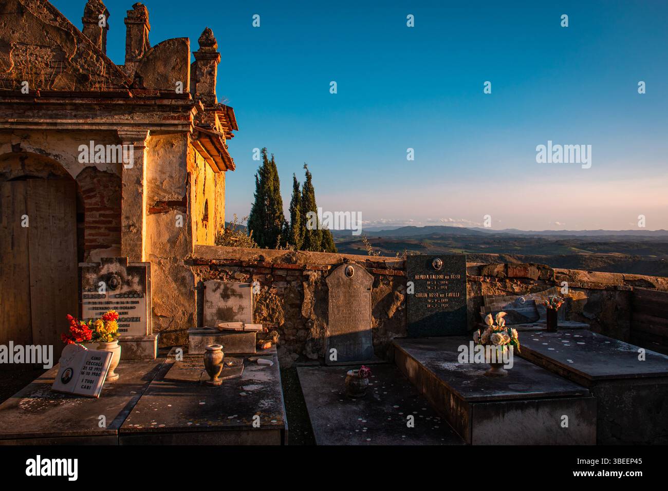 Un tranquillo cimitero di campagna in Toscana, circondato da dolci colline e serenità, offre uno scorcio della tradizione locale e della pace senza tempo. Foto Stock