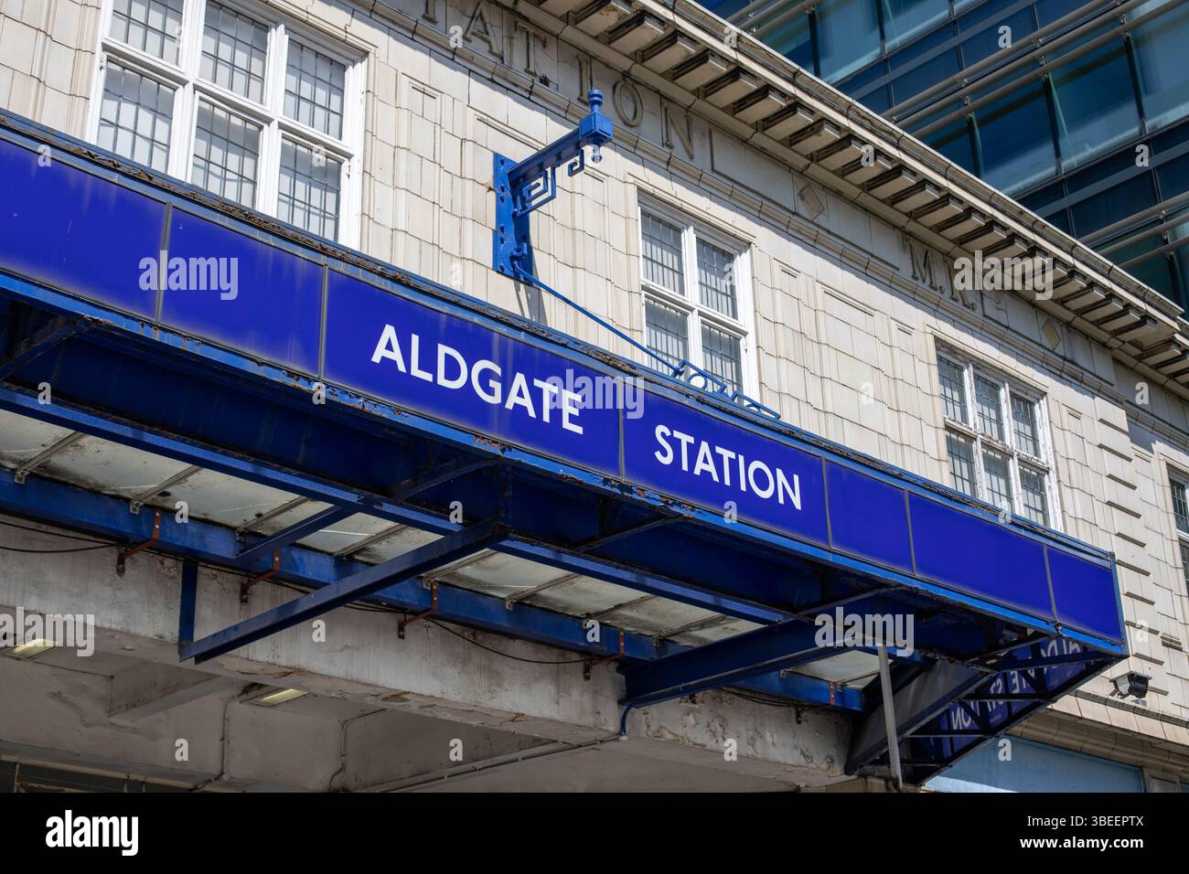 L'immagine mostra l'ingresso alla stazione di Aldgate a Londra, con il cartello della stazione e parte dell'esterno dell'edificio. Foto Stock