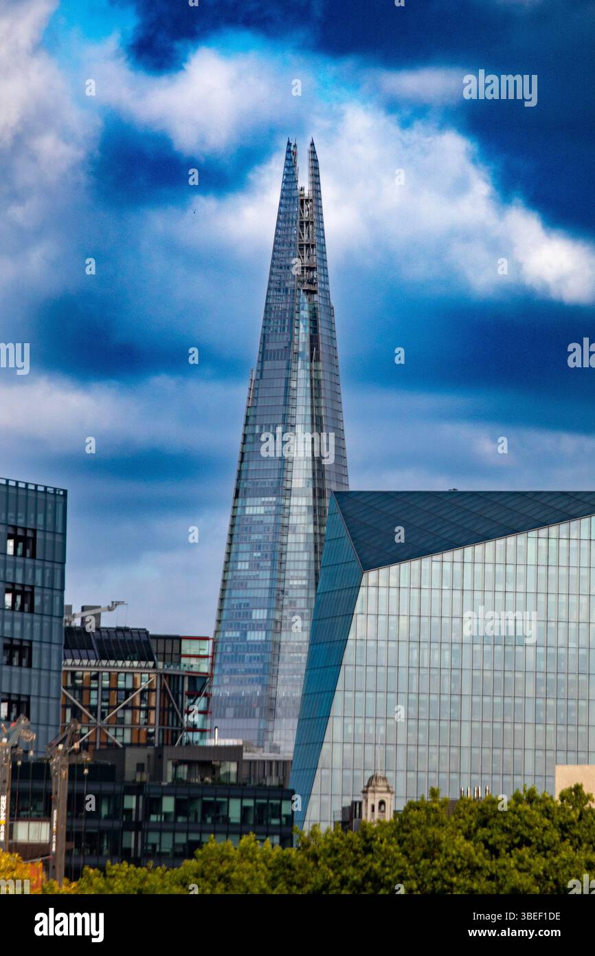 Vista dello Shard e degli edifici moderni su un cielo nuvoloso a Londra. L'architettura iconica domina il paesaggio urbano. Foto Stock