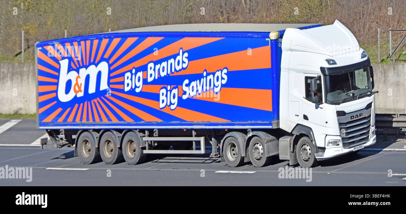 Vista laterale b&m supermercato business supply chain delivery camion & rimorchio articolato marchio B & M pubblicità & logo grafico autostrada UK Foto Stock