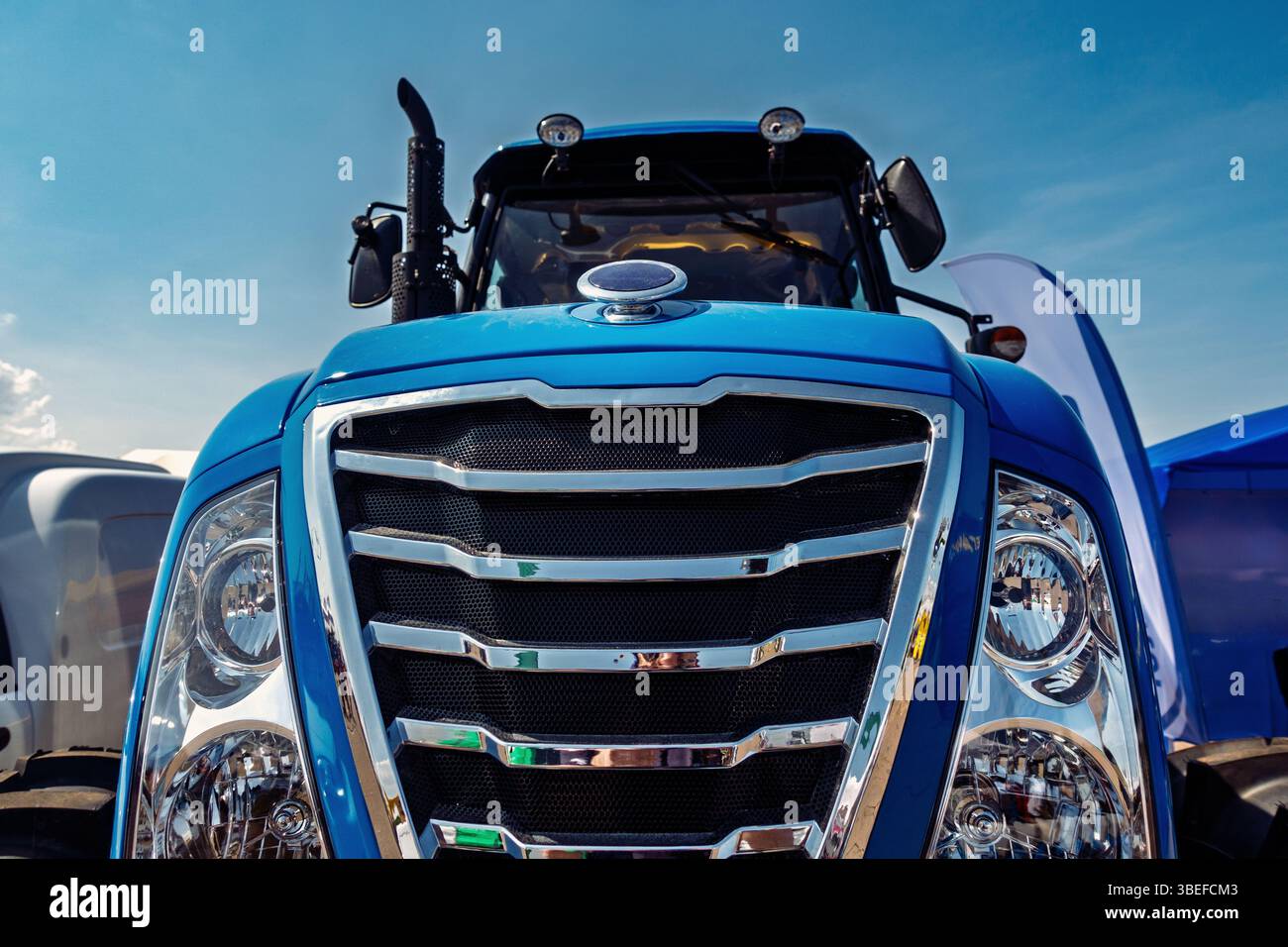 Design moderno dei trattori che cattura l'essenza dell'innovazione agricola con un sorprendente esterno blu sotto un cielo limpido. Foto Stock