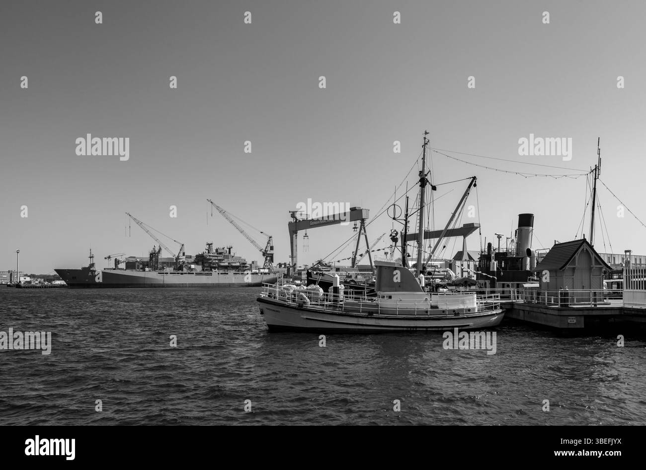 Una nave di rifornimento della Marina tedesca e ormeggiò barche civili al porto di Kiel, con gru e banchine da cantiere. Monocromatico. Solo per uso editoriale. Foto Stock
