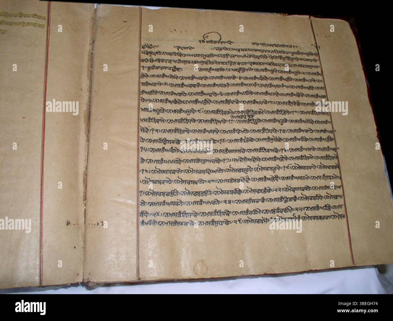 Questo manoscritto del Guru Granth Sahib, datato al XVII, XVIII o XIX secolo, presenta marcatori di margine neri e rossi, indicativi dello stile manoscritto del periodo in Sikhismo. Foto Stock