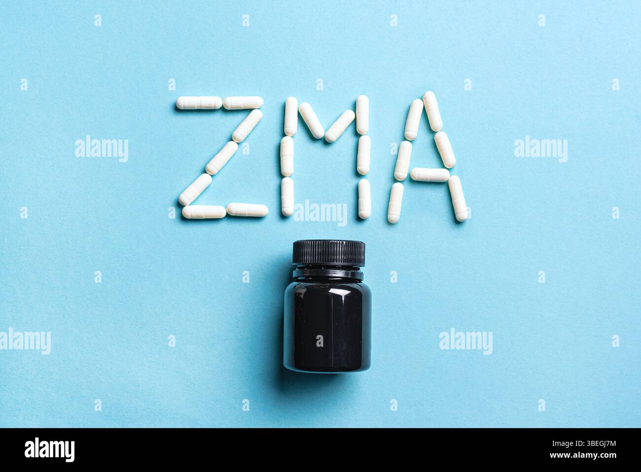 Capsule integratore ZMA e contenitore in plastica su sfondo blu, vista dall'alto. Supplemento sport per recupero notturno. Foto Stock