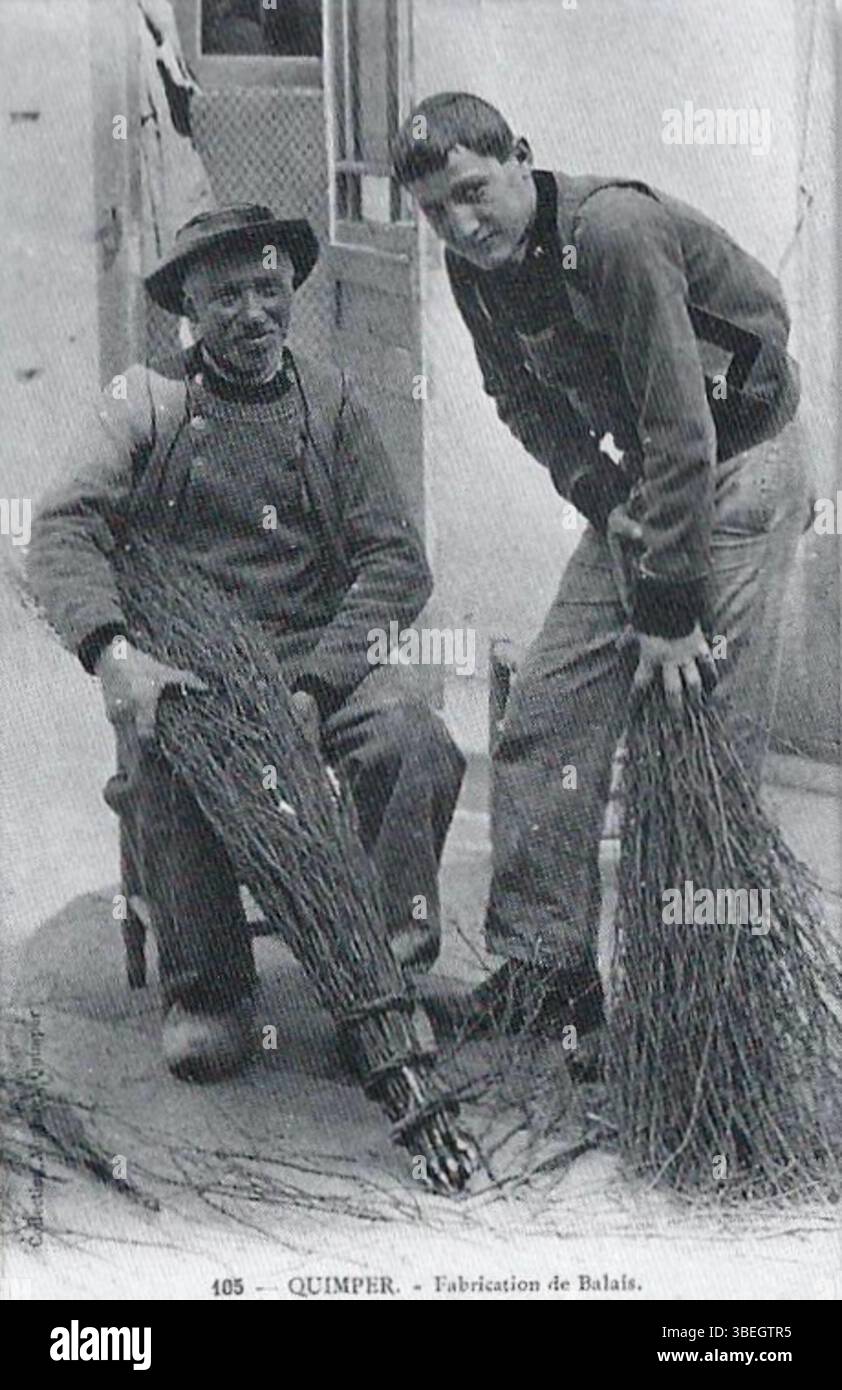 Questa immagine dell'inizio del XX secolo di circa 1920 mostra i fabbricanti di ginestre vicino alla foresta di Névet a Plogonnec, una città della Bretagna, in Francia. Gli artigiani sono raffigurati nel loro lavoro, illustrando il tradizionale commercio rurale che fu una parte importante dell'economia locale in quel periodo. La scena riflette il lavoro manuale coinvolto nella fabbricazione delle scope e il legame con l'ambiente naturale circostante. Foto Stock