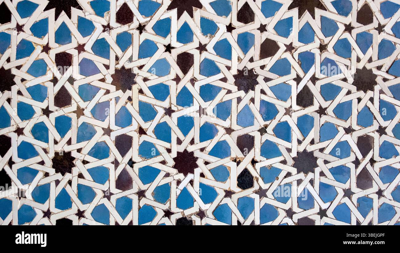 Piastrelle moresche note come azulejos, caratteristica popolare dell'architettura islamica andalusa con ripetizione di stelle geometriche e pattern poligonali in blu, bianco Foto Stock
