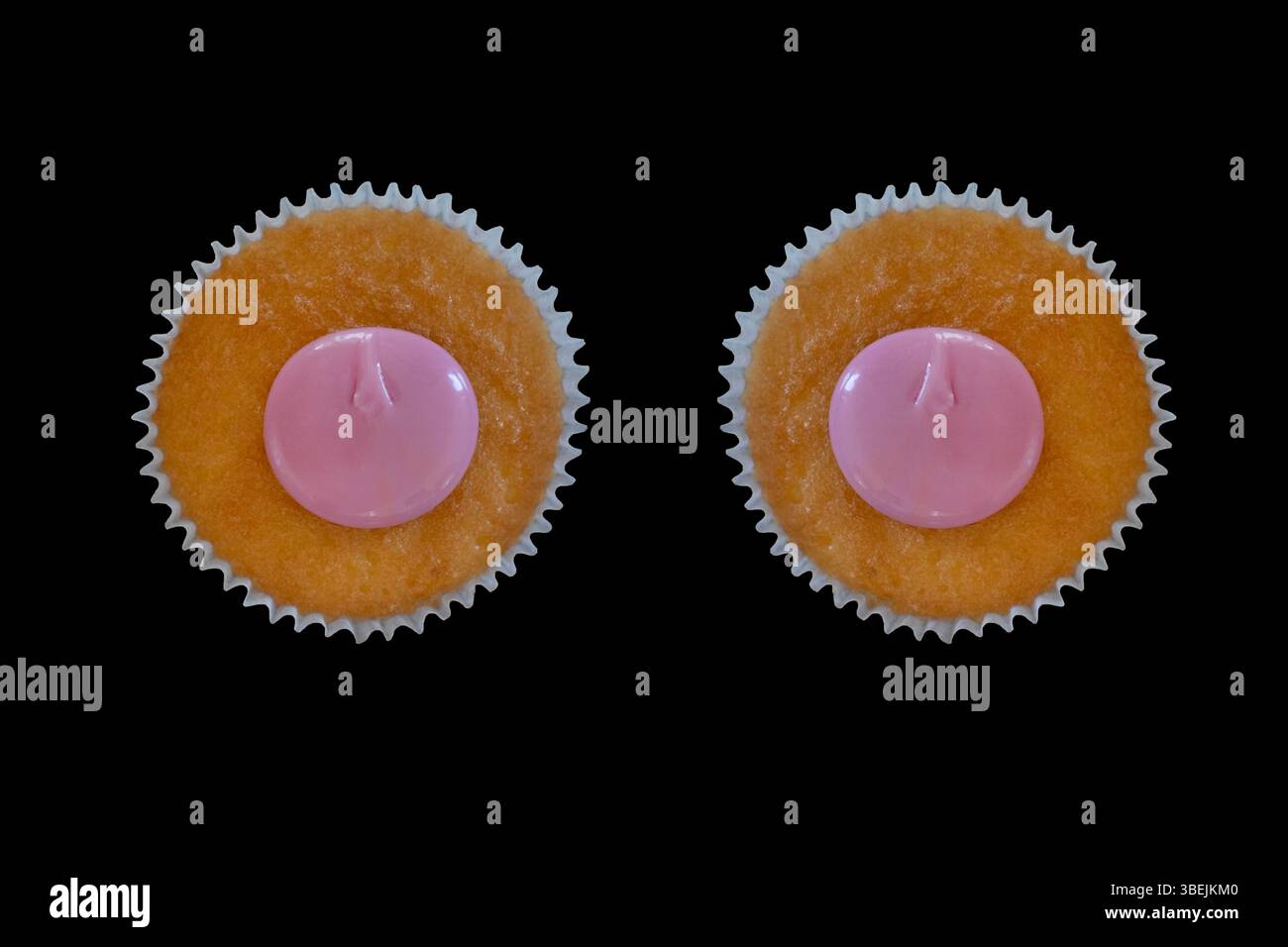 Primo piano di due cupcake dorati con centri di glassa rosa liscio, disposti fianco a fianco su sfondo nero, composizione simmetrica Foto Stock