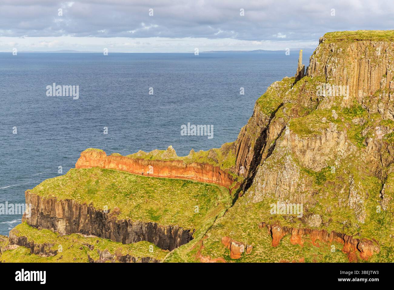 Pile di camini e strati geologici dal sentiero costiero, Giant's Causeway, Co. Antrim, Irlanda Foto Stock