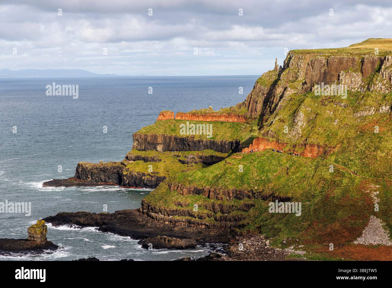 Pile di camini e strati geologici dal sentiero costiero, Giant's Causeway, Co. Antrim, Irlanda Foto Stock